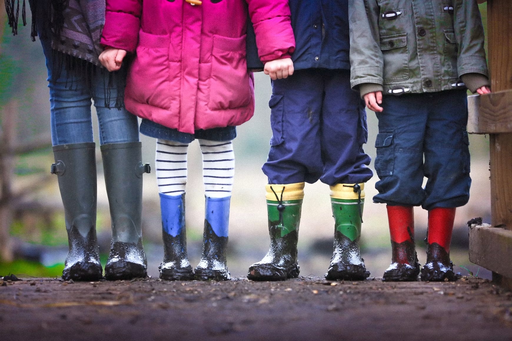 Des enfants en bottes sous la pluie.
